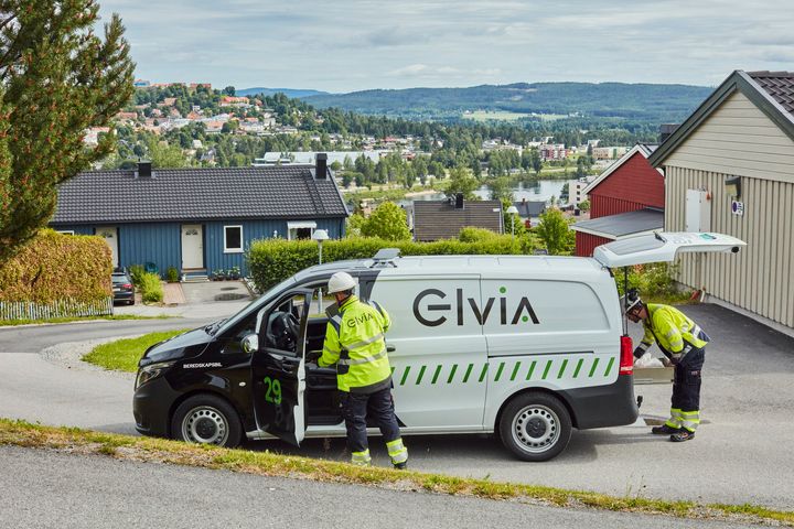 Montører fra Elvia står utenfor en bil