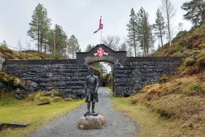 Bilde av inngangen til Hegra festning i Stjørdal, med en statue av major Hans Reidar Holtermann i front.