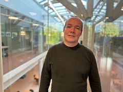 Bilde av Kaare Stang, sjef for juridisk seksjon hos Riksantikvaren, stående foran en glassvegg.