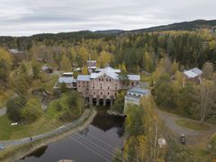Dronebildet av Kistefos Træsliberi med elven i forgrunnen, omkranset av skog.