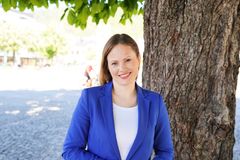 Portrettbilde av blid kvinne med kongeblå blazer som smiler mot kamera.
