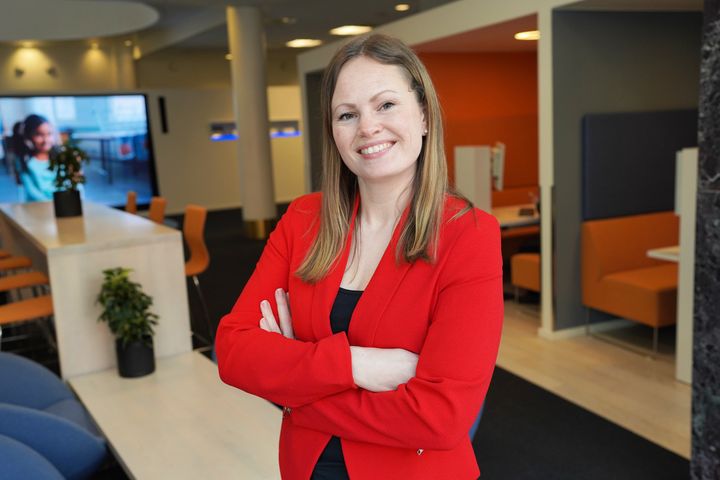 Portrettbilde av blid kvinne i rød blazer.