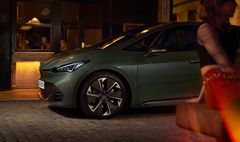 CUPRA BORN VZ parkert utenfor en bygning om kvelden, med hjulene vinklet mot fortauet.