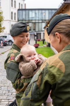 Matilde Fogstad Saubrekka (31), kaptein og styremedlem i  Militært Kvinnelig Nettverk (MKN) med datteren på armen og Amanda Bergh Schjelderup (30), løytnant og leder i MKN. Foto: Øyvind Førland Olsen