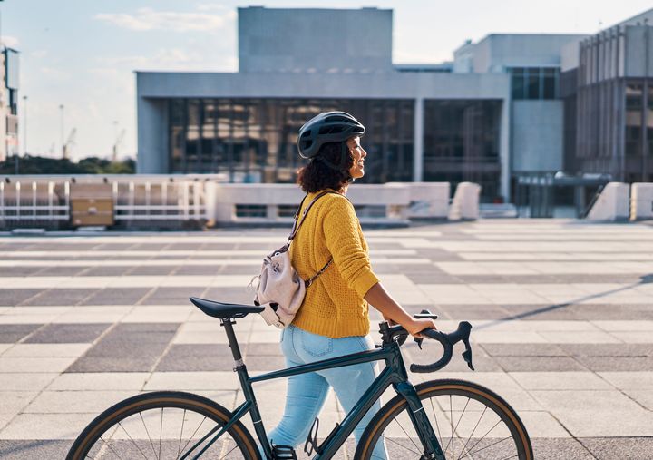 Ung kvinne går med sykkel
