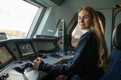 Kvinnelig student i førersetet på et tog