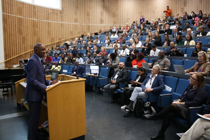 Douglas Syakalima ved talerstolen i et auditorium fylt med mennesker
