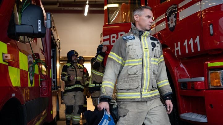 Brannmenn på tur inn i brannbil i en garasje på en brannstasjon