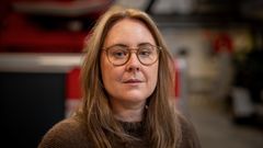 Portrettbidle av ung dame med briller inne i en garasje på en brannstasjon