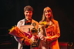 To vinnere av Forsker Grand Prix på scene med blomster og diplomer, mann og kvinne.