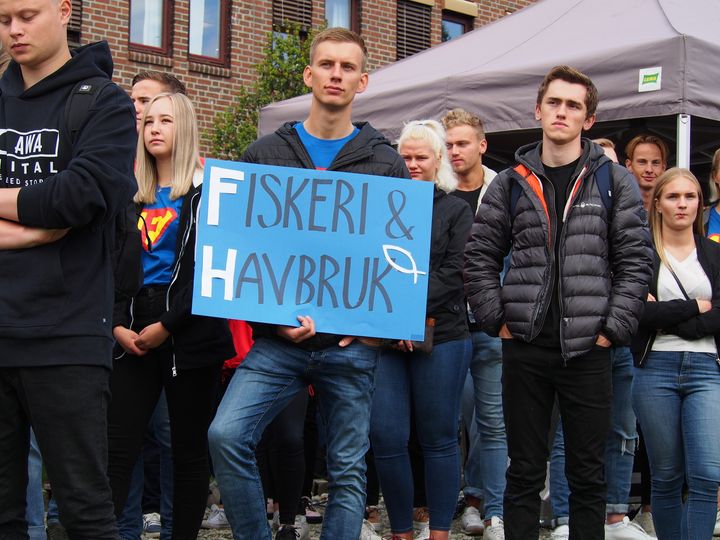 Studenter på samling ved studiestart ved UiT i Tromsø, en person holder et skilt med teksten "FISKERI & HAVBRUK".