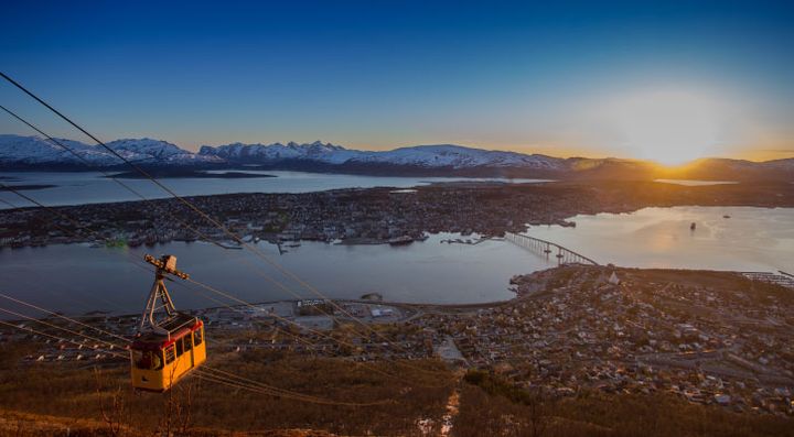 Utsikt over Tromsø ved solnedgang med taubane i forgrunnen.