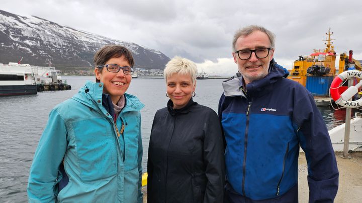 Tre personer smiler til kamera