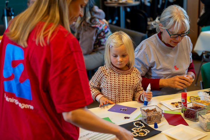 barn som lager hobbyaktivitet mens voksne hjelper til