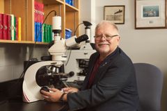 En mann ved mikroskop på et laboratorium.