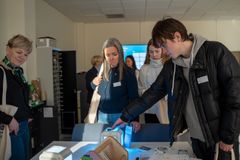 Ungdom og voksne trykker på en elektronisk lysende boks