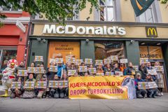 Protest foran McDonald's Storgata mot bruk av turbokylling, med demonstranter som holder plakater.