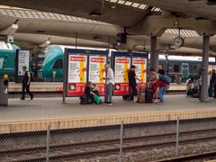 Annonsen "Not Lovin' It" på en togperrong på Oslo S, med reisende i nærheten.