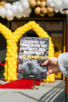 En person holder en brosjyre foran en McDonald's. brosjyren tekst sier: "Tusenvis av nordmenn tar en pause fra McDonald's. Vet du hvorfor?"