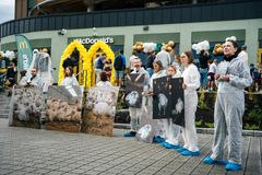 En gruppe mennesker kledd i hvite dresser holder plakater av kyllinger utenfor McDonald's ved Nadderud Fotballstadion.