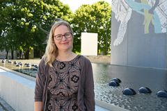 Kvinne i kjole med grønne trær i bakgrunnen