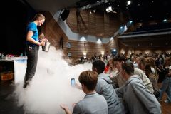 Ungdommer er publikum mens et kjemieksperiment demonstreres fra scenen