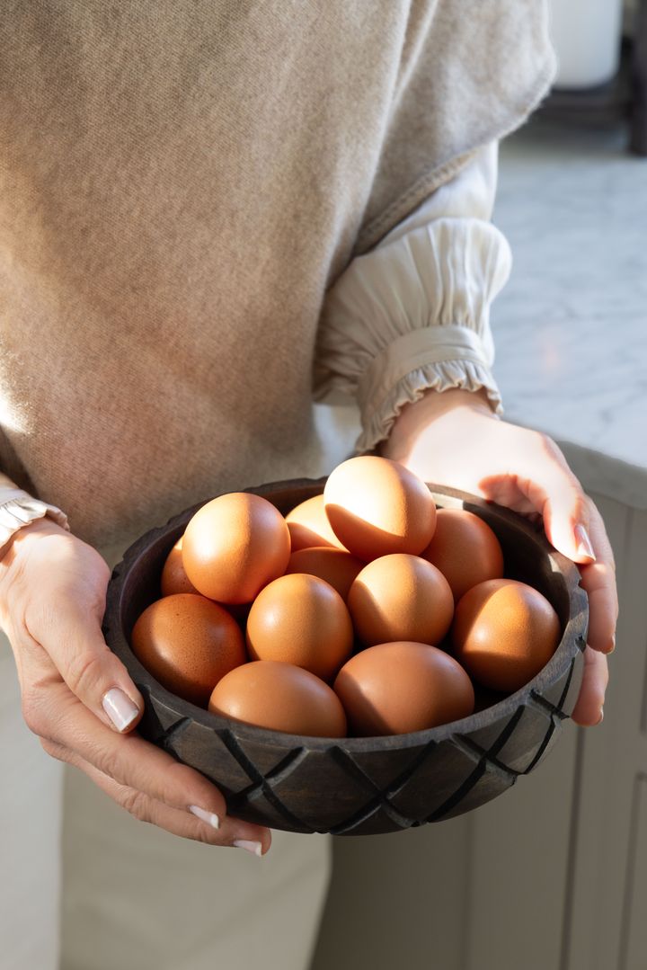 En%20person%20holder%20en%20trebolle%20fylt%20med%20brune%20egg.