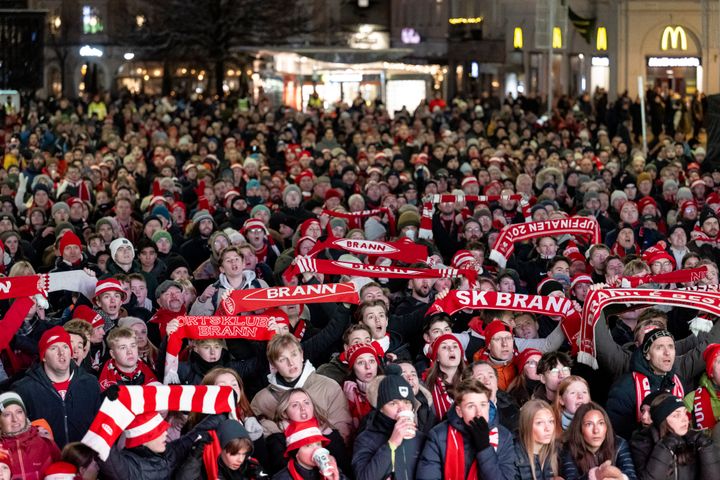 Over 3500 Brann-tilhengere samlet på Torgallmenningen for å se kamp på storskjerm. De er kledd i rødt og hvitt, mange med skjerf og luer.