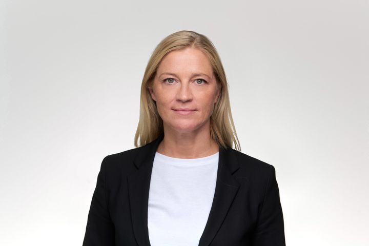 Portrett av smilende dame med lyst hår og dressjakke