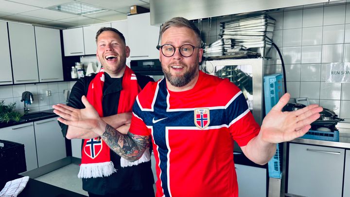 – Enkel og god mat hører med til fotballkampen, og det trenger ikke være komplisert, sier Andreas Ingul, kokk og matfaglig rådgiver i Matprat. Kollega Pål Henrik Kristiansen, senior kommunikasjonsrådgiver i Matprat og ihuga fotballfan, setter pris på kokkens tips. Foto: matprat.no
