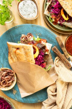 Berlin döner kebab er ikonisk streetfood, med krydret dönerkjøtt, friske grønnsaker og sauser rike på smak. Alt servert inni et toastet, mykt pidebrød.