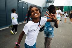 Jente på Camp W som smiler og gir peacetegn til kameraet