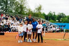 Casper Ruud står sammen med fire barn på en tennisbane