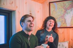 En mann og en kvinne ler på hytte