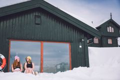 To personer foran et stort vindu på en betjent DNT-hytte