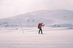 En person på ski med ryggsekk i et snødekt fjellandskap.