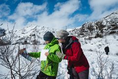 personer som leser på et ark hvor overskriften er påskequiz. det er snødekt landskap rundt dem og blå himmel