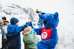 barn som gir "high five" til en person utkledd som en blå rev.