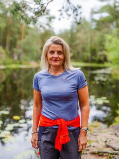 Kvinne i skogen ser i kameraet