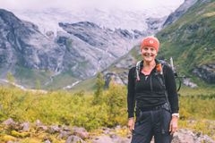 Kvinne i fjellandskap smiler mot kamera.