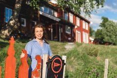 Kvinne smiler foran Gjevilvasshytta, en tradisjonell rød hytte i Trollheimen.