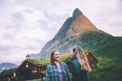 To kvinner smiler foran Innerdalshytta med Innerdalstårnet i bakgrunnen.