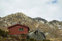 Rød DNT-hytte i steinete fjellandskap i Ryfylke.