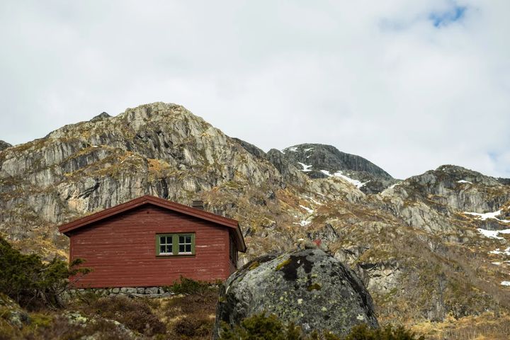 Rød DNT-hytte i steinete fjellandskap i Ryfylke.