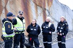 Fem tollere og en tjenestehund står i bildet foran en fjellvegg. To av tollerne har på seg refleksvest og capser, mens de resterende har på seg ordinær tolluniform.