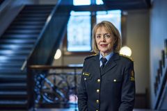 Portrett av tolldirektør Benedicte Bjørnland foran en trappegang. Bjørnland bærer en tolluniform og stirrer smilende inn i kameraet.