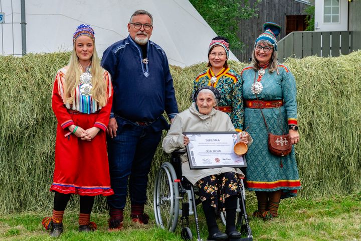 Oliva Nilsen fra Manndalen vant Buošši-prisen 2025. Her avbildet med festivalsjef for Riddu Riđđu, Sajje Solbakk, daglig leder for Senter for nordlige folk, Svein Leiros, nestleder i styret ved Senter for nordlige folk og styreleder for Riddu Riđđu, Bente Ovedie Skogvang.