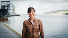 Voksen kvinne i brun skinnjakke på kaikanten i Bodø. Foto