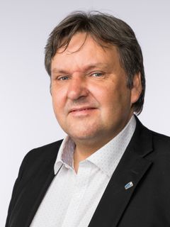 Portrettbilde av voksen mann i dressjakke og hvit skjorte