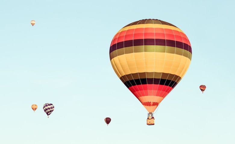 Seks fargerike luftballonger på bakgrunn av blå himmel